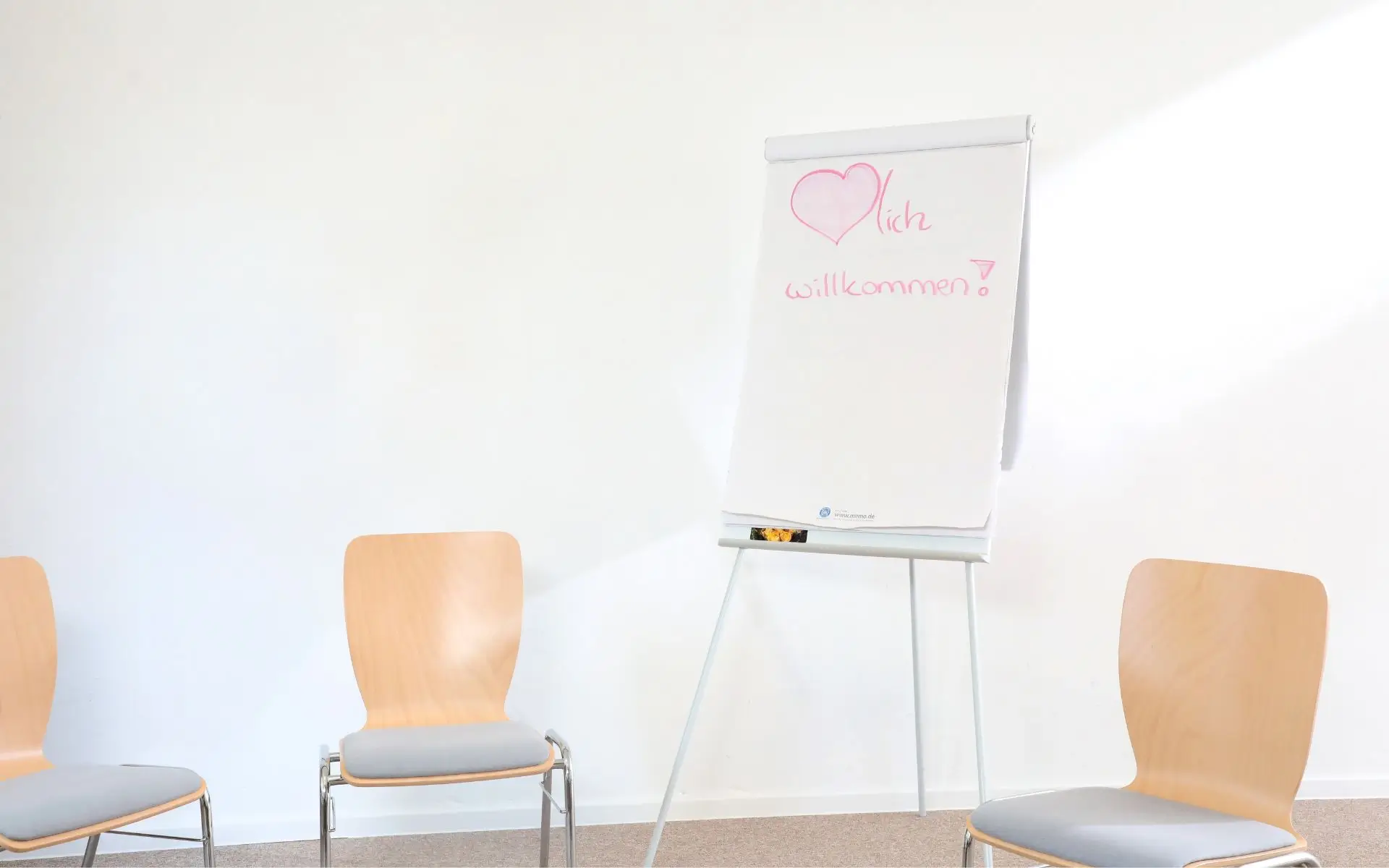 Seminarraum mit Flipchart "Herzlich Willkommen"